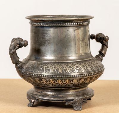un vase en argent posé sur une table en bois