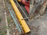 une voiture rouge garée sur un parking, à côté d'un tas de ferraille