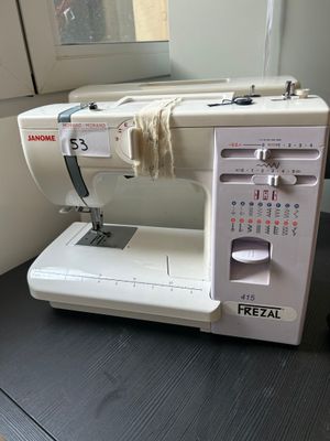 a white sewing machine sitting on a table next to a window