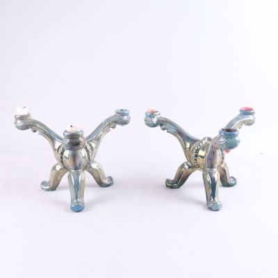 deux figurines de chats en argent posées sur un fond blanc