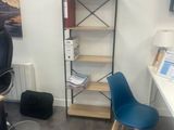 a desk with a chair and a book shelf in the corner
