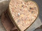 a heart shaped box sitting on the ground next to a pair of boots