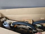 a person holding a bike in a box with other items in it