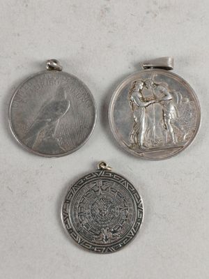 trois pièces d'argent et une pièce d'argent posées sur une surface blanche