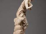 an image of a statue of a woman on a rock