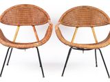 pair of wicker chairs with black metal legs on a white background