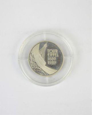 un gros plan d'une pièce de monnaie dans un récipient en plastique posé sur une surface blanche