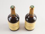 two bottles of wine sitting on top of a table next to each other