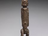 an image of a statue of a person standing on top of a wooden base