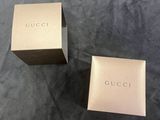two boxes of gucci perfume sitting on top of a table
