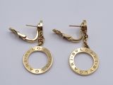 two pairs of gold earrings with the names of two different countries on them