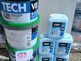plusieurs seaux de peinture posés par terre les uns à côté des autres