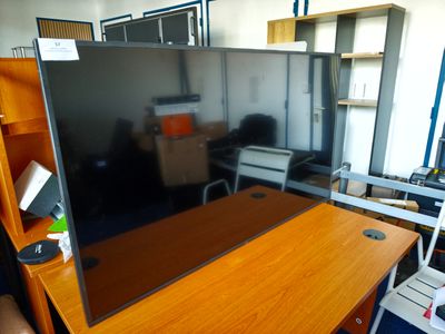 un bureau avec un écran et une chaise dans la pièce