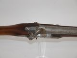 an old rifle mounted on a wall with a glass holder