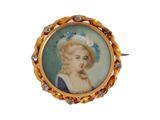 portrait d'une femme en robe bleue, une fleur dans les cheveux, sur une broche en or