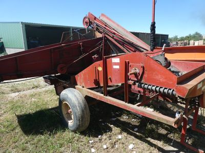 une image représentant une grande machine rouge garée dans l'herbe