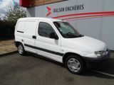 la petite camionnette blanche est garée devant un bâtiment
