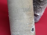 a bottle of wine sitting next to a bottle of wine on a red surface