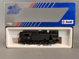 la boîte est ouverte et laisse apparaître une locomotive noire à l'intérieur