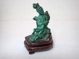 une petite statue représentant un dragon, posée sur un socle en bois
