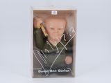 the doll is in a box with a picture of a man holding a baseball bat