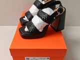 an orange box with a pair of black and white sandals on top of it