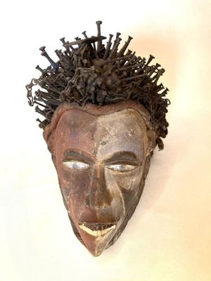 une image représentant un masque en bois accroché au mur