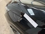 a sticker on the hood of a car that is parked on the side of the road