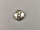 une pièce d'argent sur laquelle figure une statue, posée sur une table