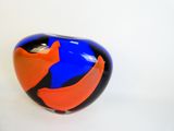 a blue and orange vase sitting on a white surface