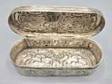 an antique silver box with ornate designs on the inside