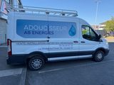 a white van parked in a parking lot next to a building