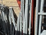 a pile of metal pipes leaning against a brick wall