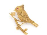 gold plated bird brooch with ruby eyes on a branch