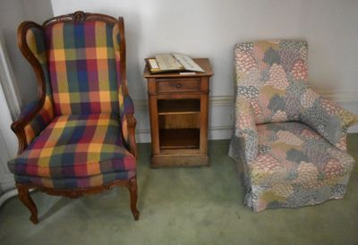 a chair and a chair with a plaid cover in a room