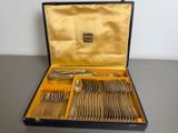 silverware in a blue case on a table with a gold lining