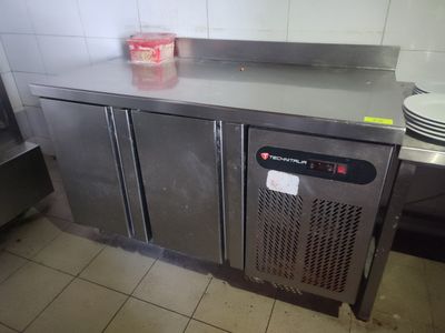un plan de travail en acier inoxydable dans une cuisine, sur lequel sont posées des assiettes