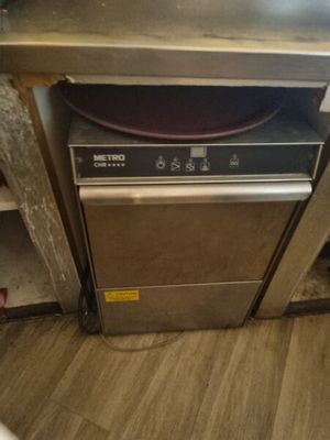 an image of a dishwasher in a dirty kitchen