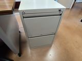 un classeur blanc posé à côté d'un bureau en bois