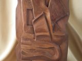 statue d'un homme coiffé d'un chapeau, posée sur un socle en bois