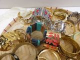 many different types of rings and bracelets on a tray