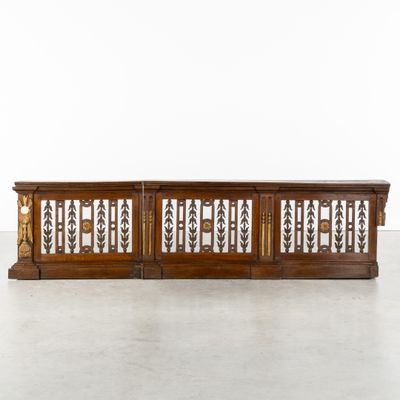 une console ancienne en bois avec des éléments en fer forgé sur les côtés
