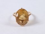 a close up of a gold ring with a faceted citrine stone