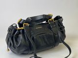 a black leather purse with a gold chain strap