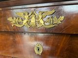 une commode en bois ornée de décorations en laiton