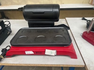 une photo d'une plaque de cuisson électrique rouge et noire posée sur une table