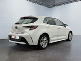 a white toyota corollant is parked in a large room