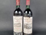 two bottles of red wine sitting next to each other on a table