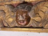 a wooden carving of a face on the wall