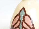 a white vase with a brown and blue design on it